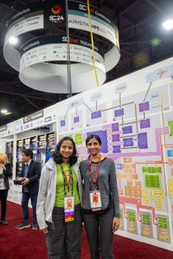 Two women in front of a network map