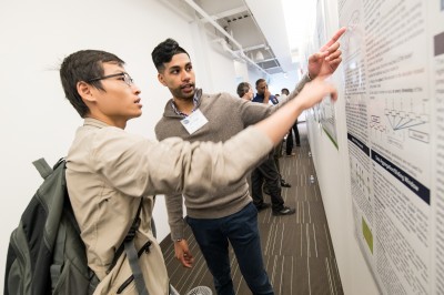 Photograph of two students looking at a poster.