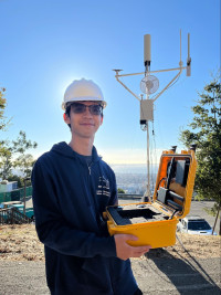 Young man in hard hat holding laptop