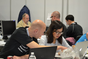 man looking over woman's shoulder at a laptop